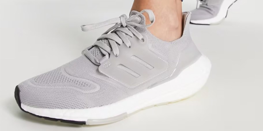 person wearing gray adidas shoes