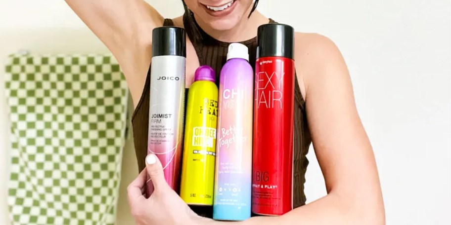 woman holding 4 bottles of hair spray