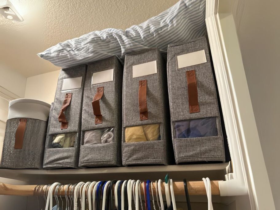 bed sheet organizer 4-pack on closet shelf with pillow on top of them