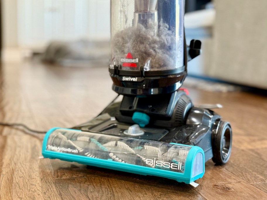 vacuum on hardwood floor with dirt inside