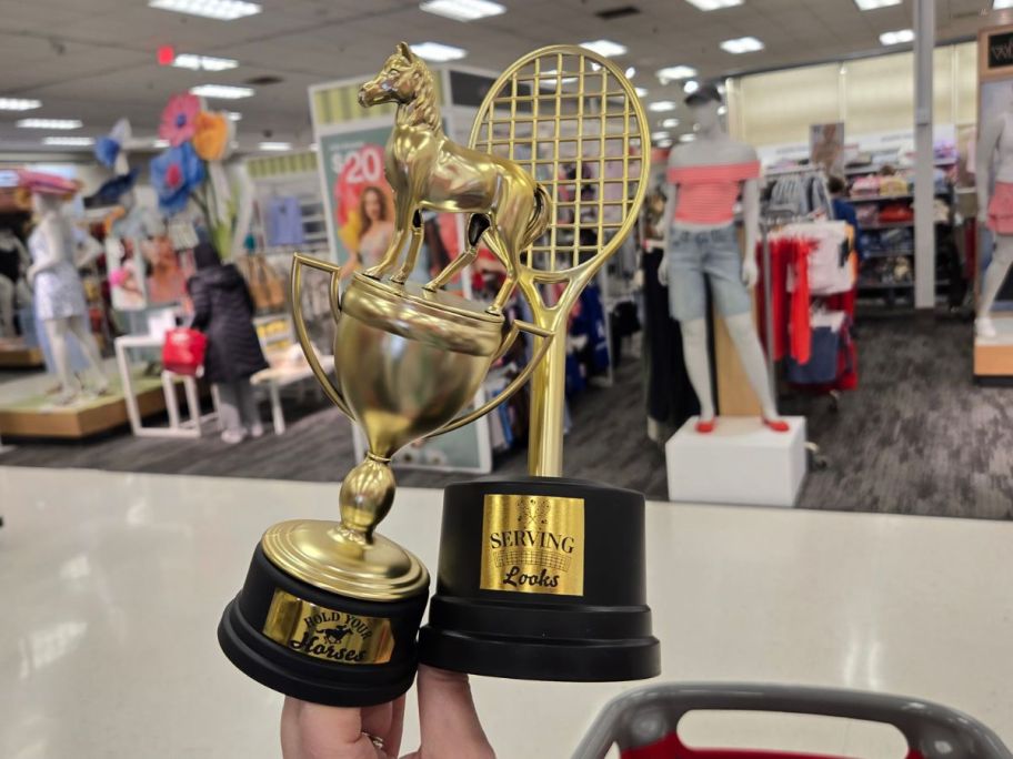 a black and gold horse and tennis racket trophy in hand in store