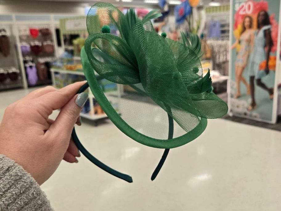 a green fancy headband in hand in store