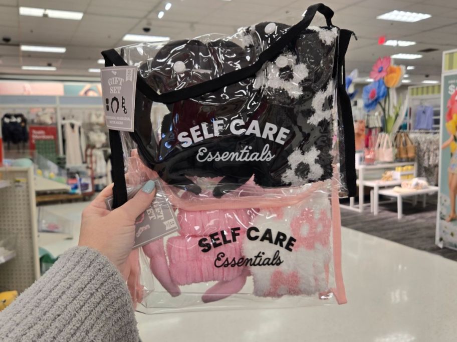 a black and a pink Self Care Essentials Gift Set in hand in store