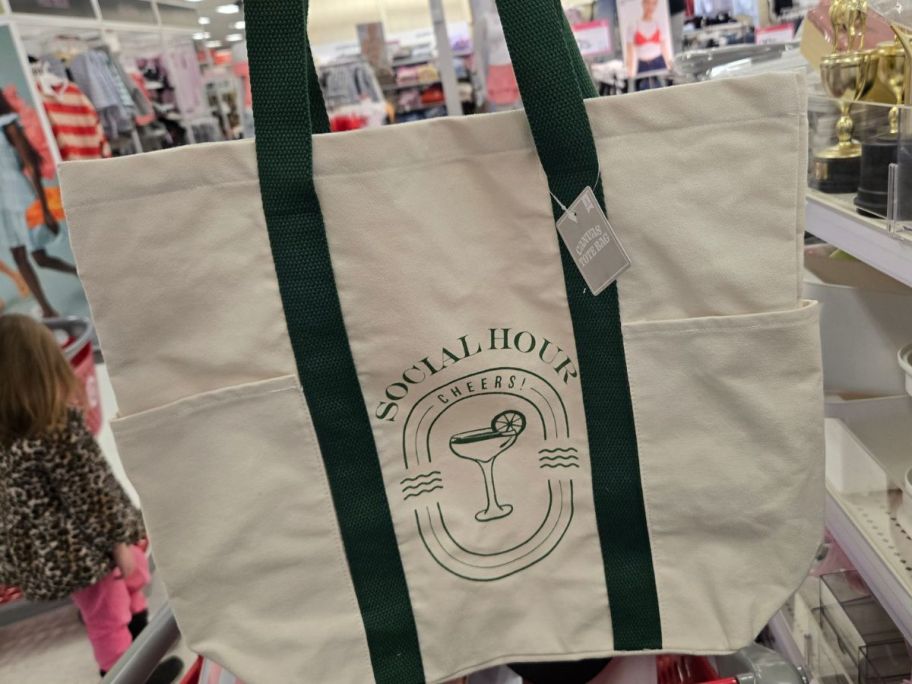 a black and white canvas tote bag in hand in store