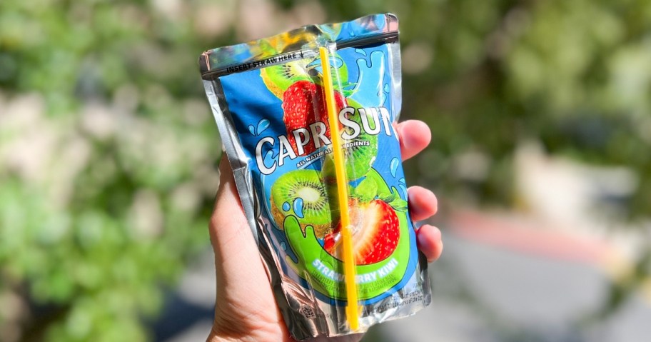 hand holding a Capri Sun drink pouch outside