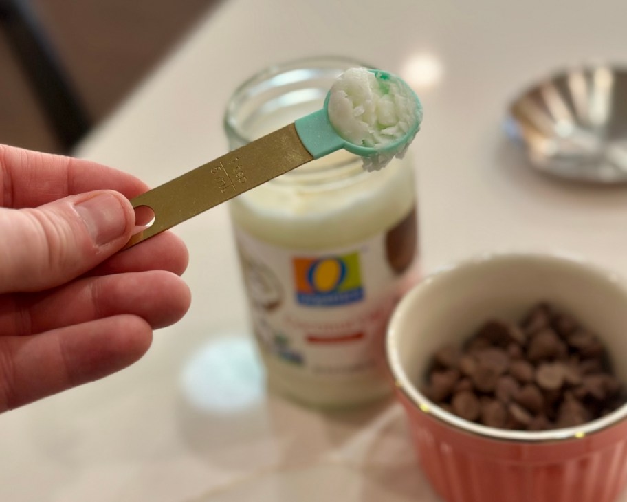 hand holding teaspoon with coconut oil