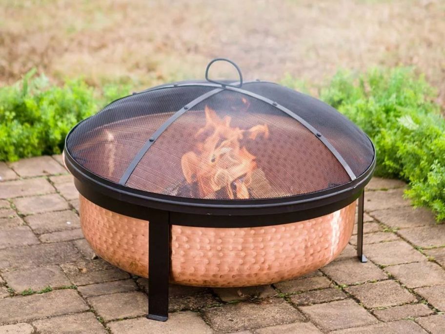 Better Homes & Gardens Wood Burning Copper Fire Pit on patio