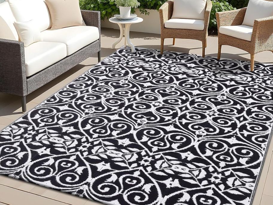 a black and white floral print outdoor rug on a patio