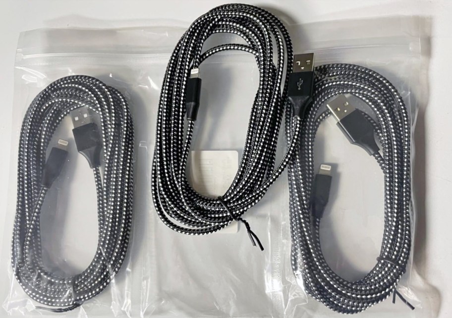 three long black charging cables with their plastic packaging