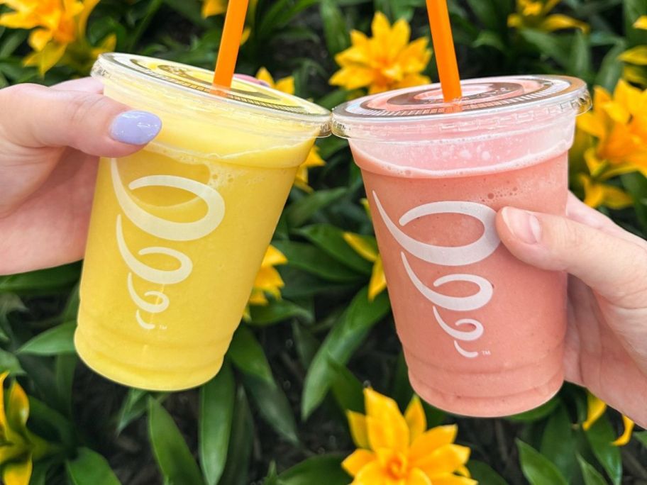 two hands holding Mango-A-Go-Go or Strawberry Whirl Smoothies