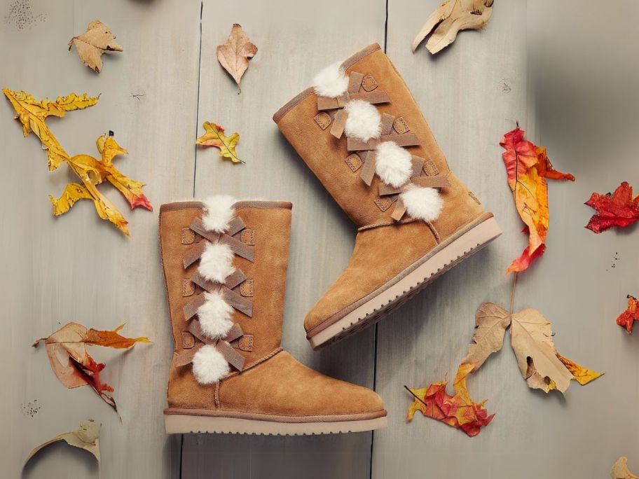 brown koolaburra by ugg boots on wood floor with leaves around them