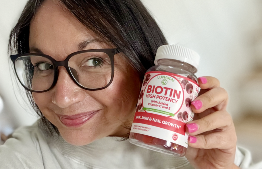 woman holding bottle of biotin gummies