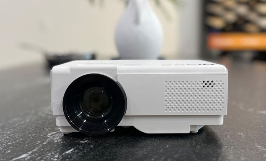 a white mini movie projector sitting on a counter top