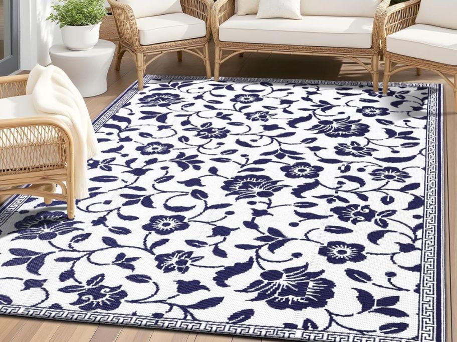 a navy and white floral print outdoor rug on a patio