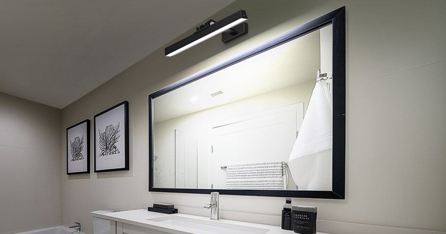 bathroom with picture light hanging above a mirro