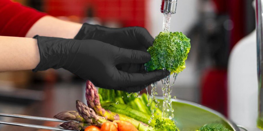 hands in black gloves washing brocoli