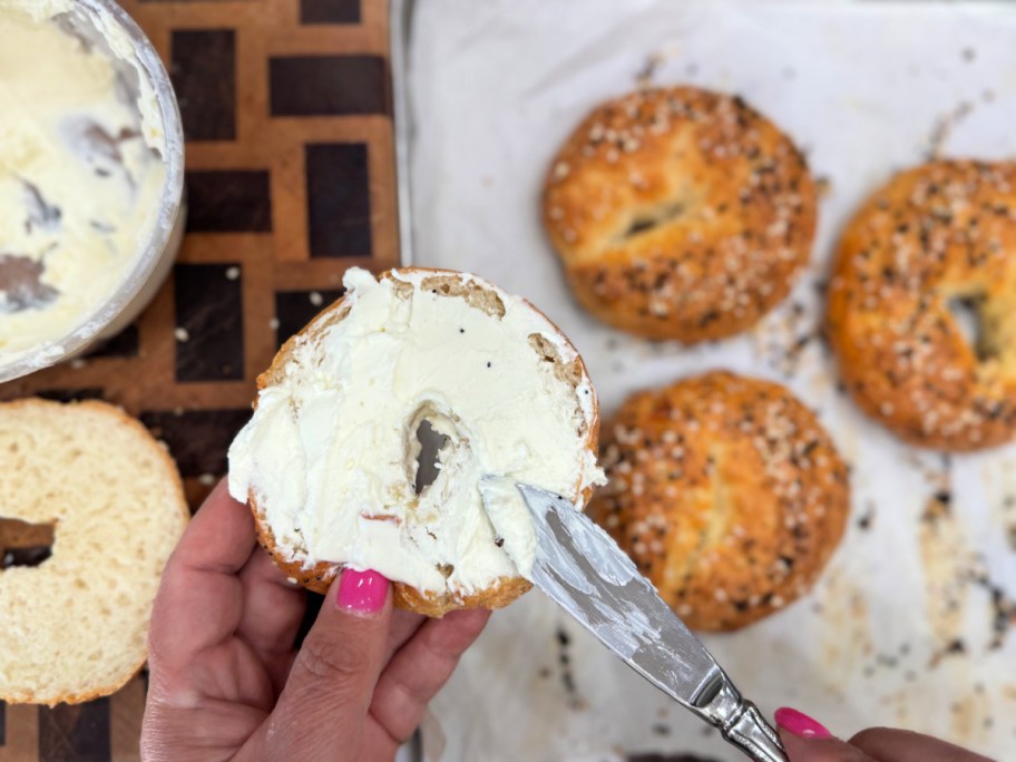 spreading cottage cheese on a cottage cheese bagel