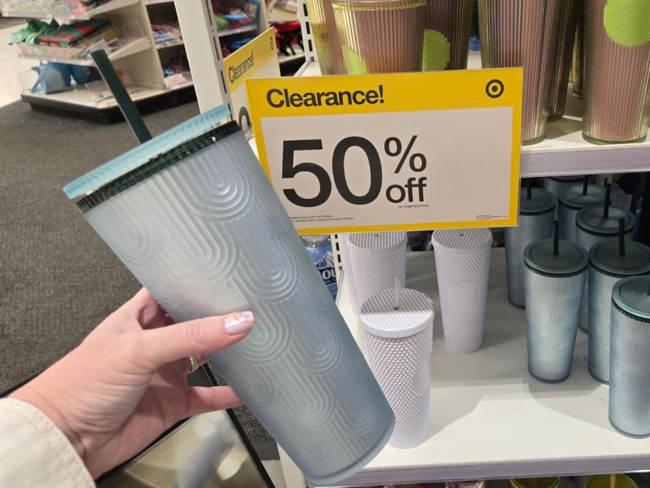 Starbucks Soft Touch 24oz Tumbler in hand in store in front of clearance sign