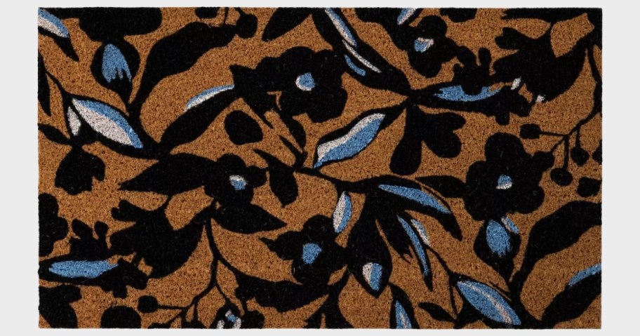 a coir doormat with black, white and blue flowers printed on it