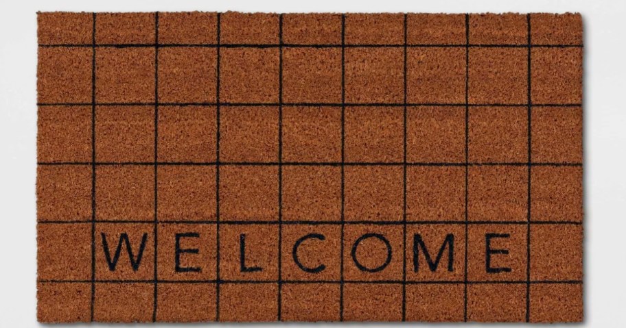 a coir doormat with a black grid and "Welcome" printed on it