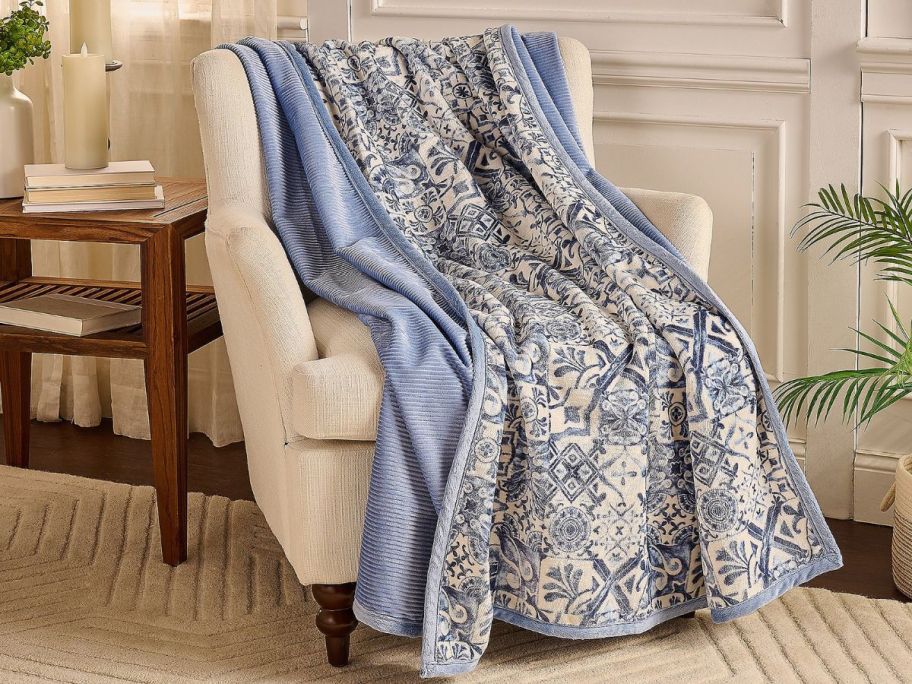 blue patterned Home Reflections Reversible Rib & Plush 60 x 80 Printed Throw on beige chair