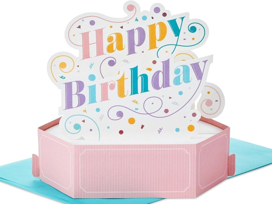 a colorful Happy Birthday pop up card on a blue envelope