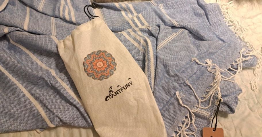 A blue Turkish bath towel on a bed