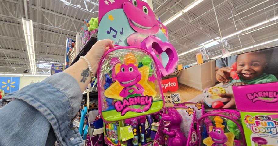 A person holding a Barney Backpack