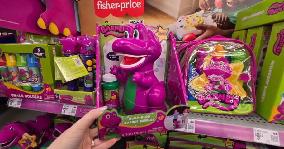 A person holding Barney Bump-N-Go Bubbler