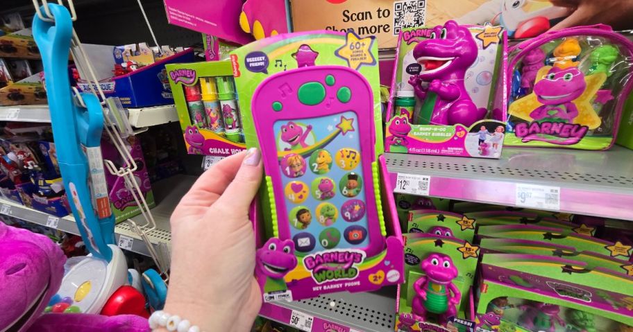 A person holding a Barney Phone toy