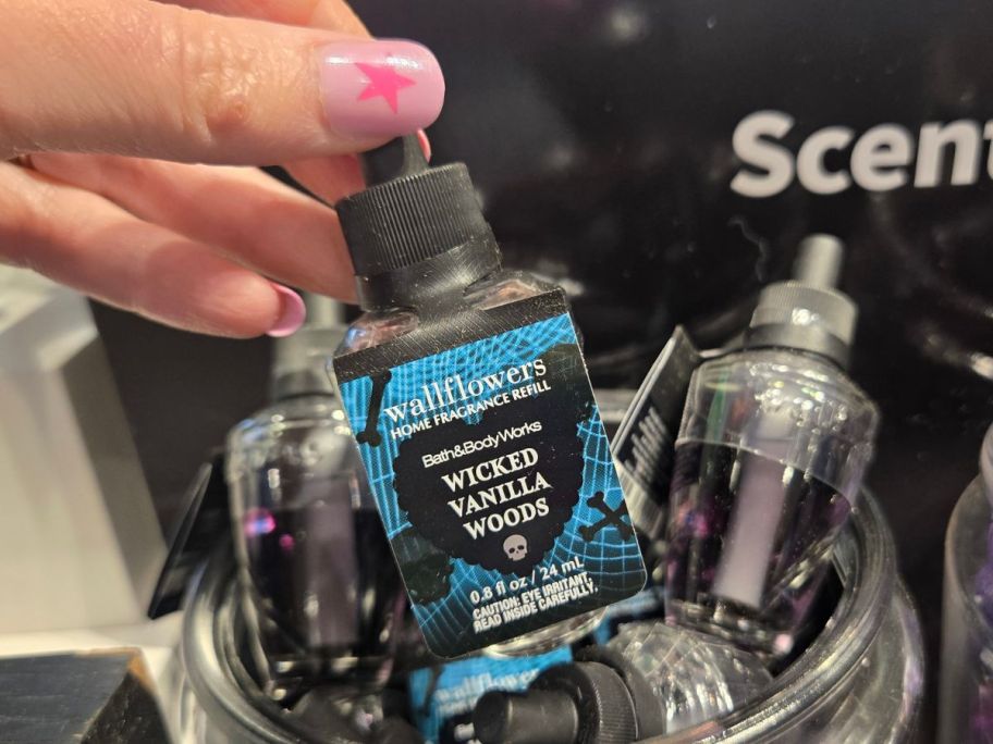 Hand holding a Wicked Vanilla Woods Wallflower Refill from Bath & Body Works