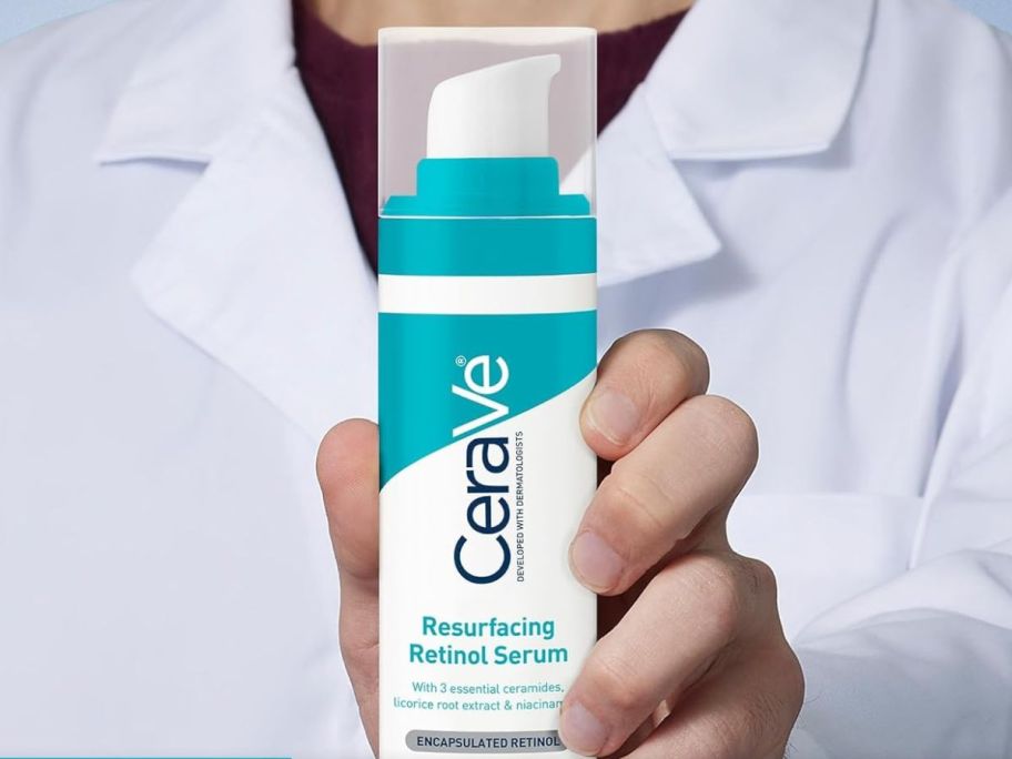 person in a lab coat holding a bottle of CeraVe Resurfacing Retinol Serum For Post-Acne Marks