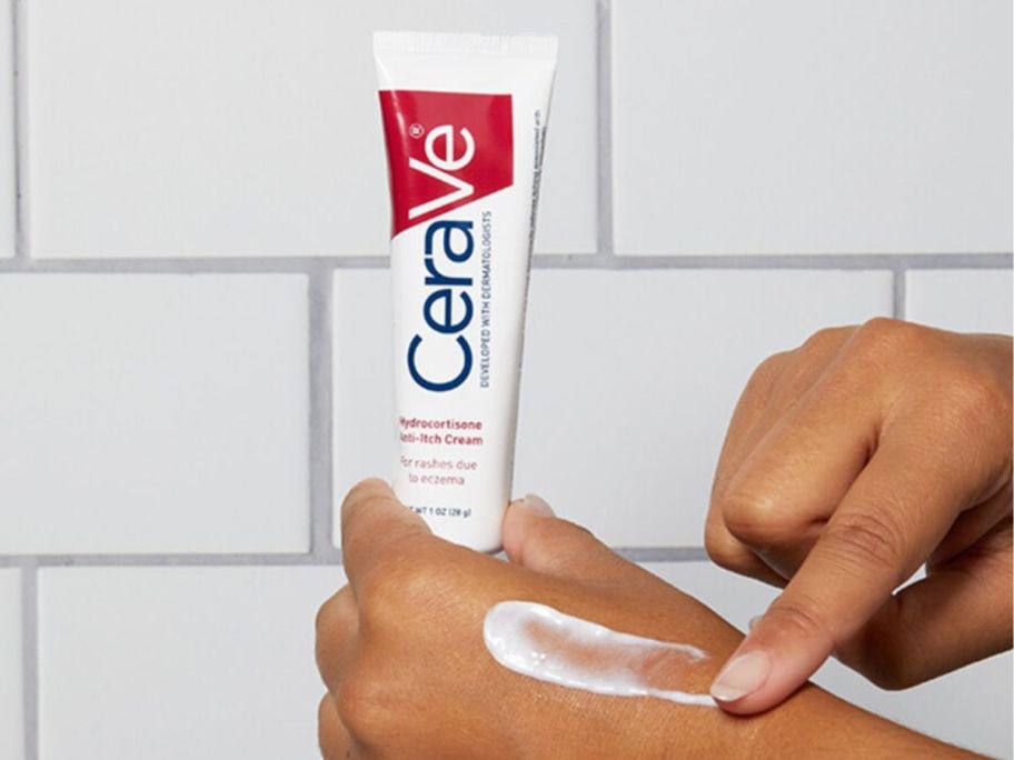 Human hands with one hand holding a tube of CeraVe 1% Hydrocortisone Anti-Itch Cream and the other running some cream on the back of their hand