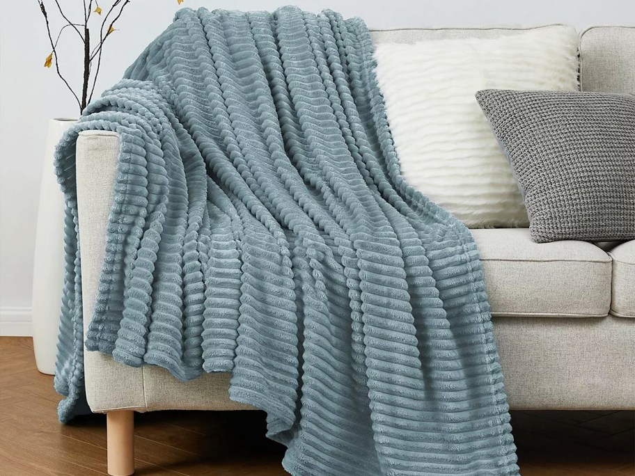 blue ribbed throw blanket draped over couch