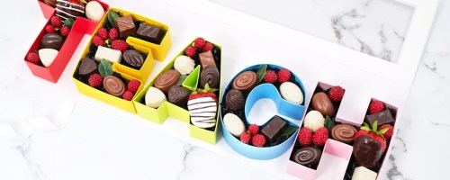 colorful letters that spell out "teach" filled with chocolates and strawberries