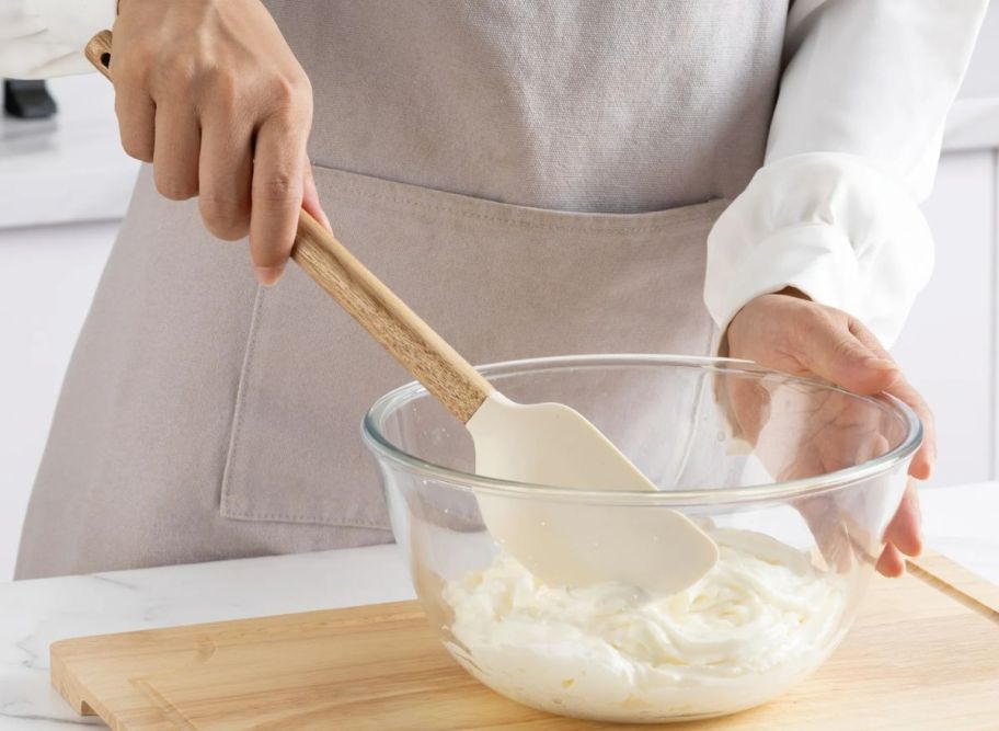 a womans hand stirring dry ingredients in a mixing bowl