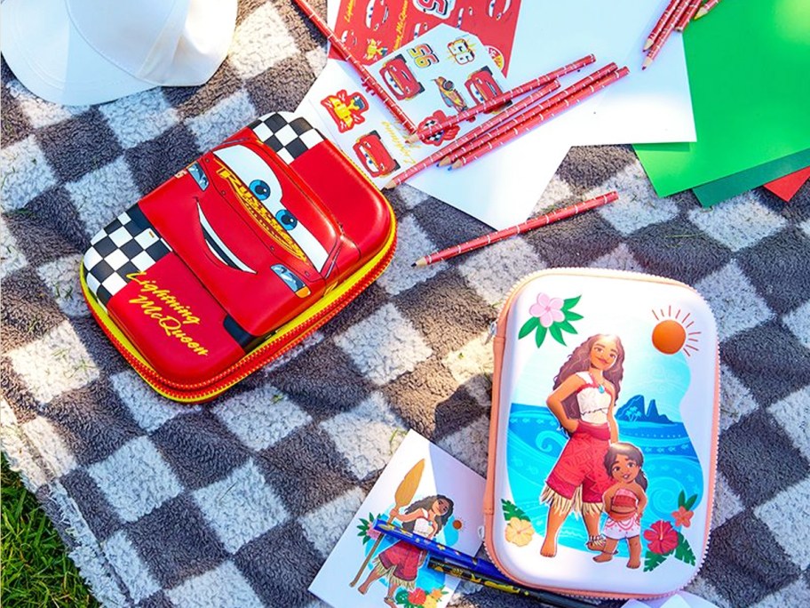 cars and moana themed stationary kits on a checkered blanket