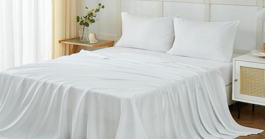 A bed with white sheets on it 