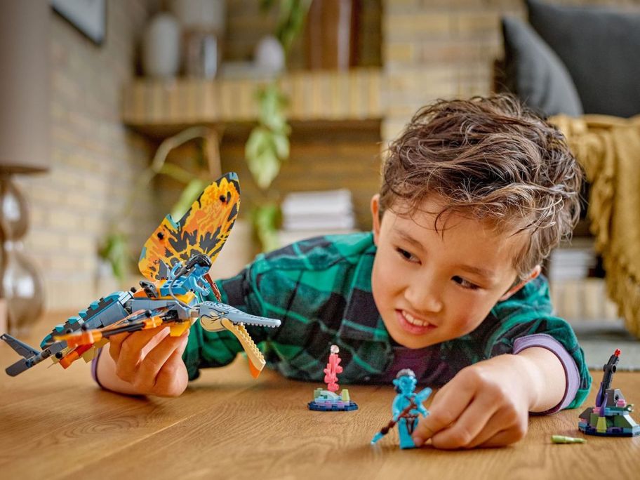 kid playing with LEGO avatar playing set on a table