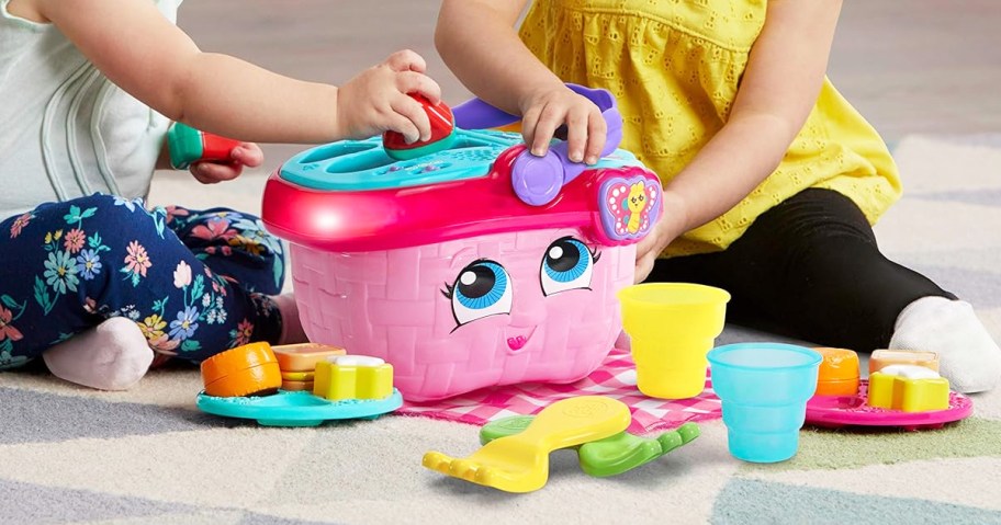 two girls playing with pink LeapFrog Shapes & Sharing Picnic Basket set