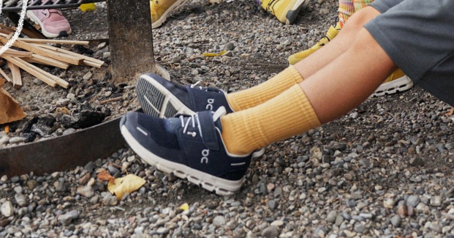 boy wearing a pair of black and white On shoes