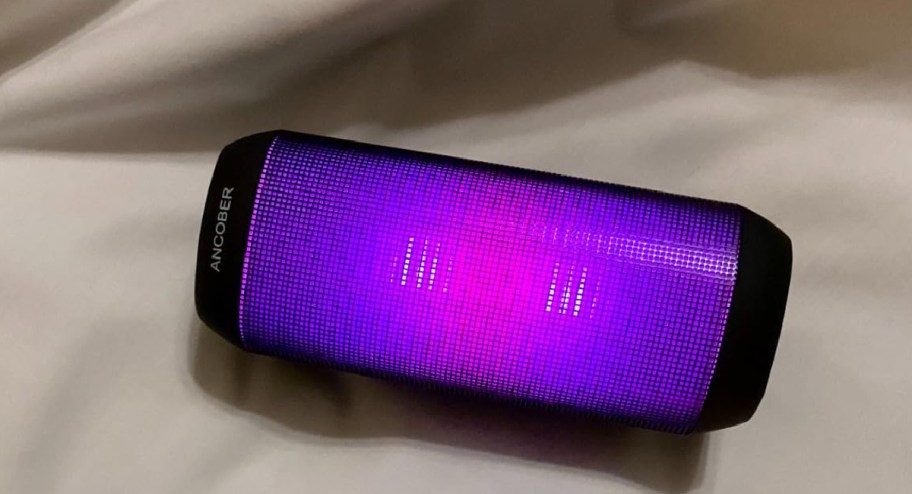 Speaker-with-pink-color-displayed-on-a-bed.