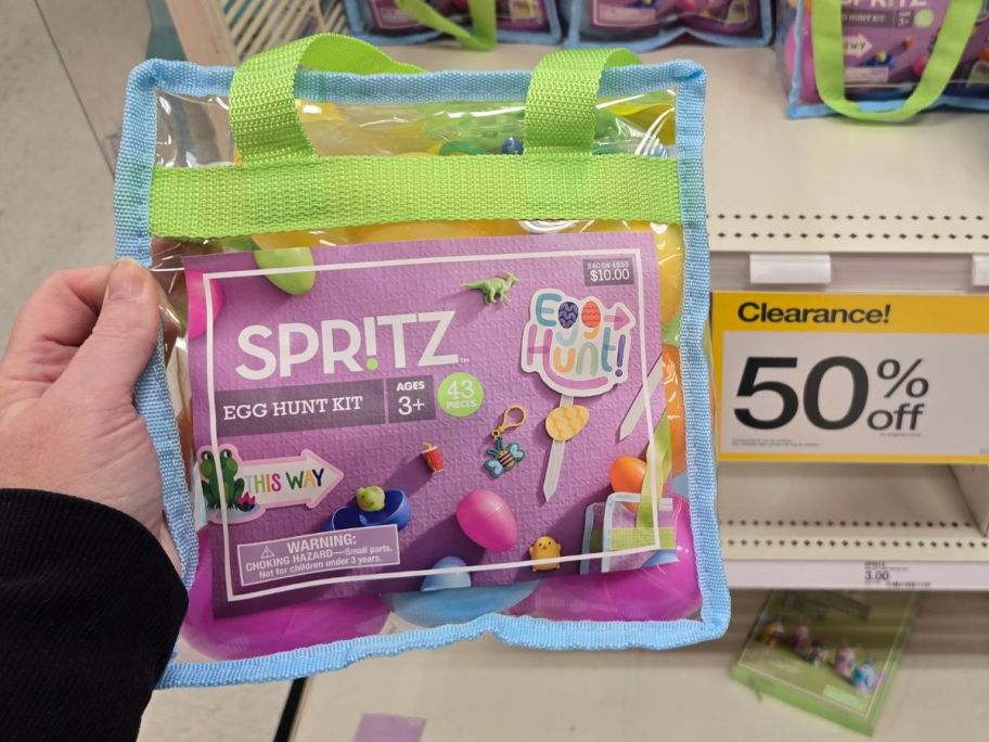 hand holding a Spritz Egg Hunt Kit next to a 50% off clearance sign