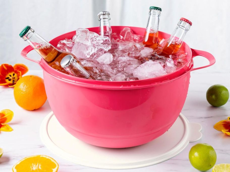 Large tupperware bowl filled with ice and beverages in glass bottles