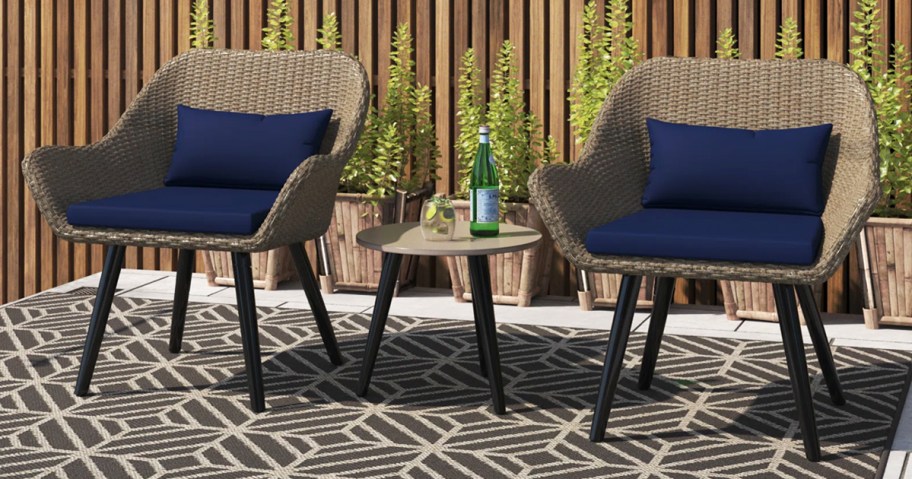 wicker chairs with navy blue cushions and side table