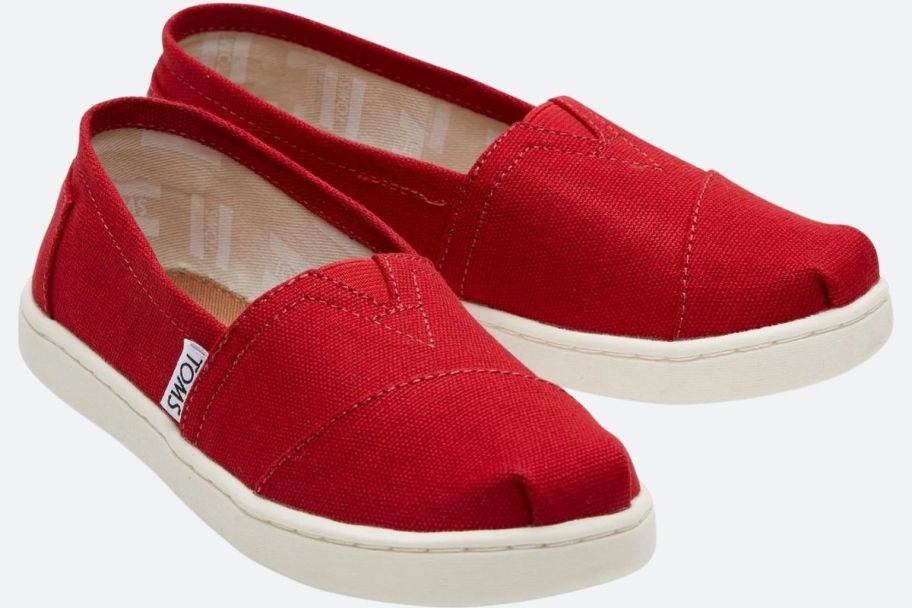 a pair of red canvas kids slip on shoes