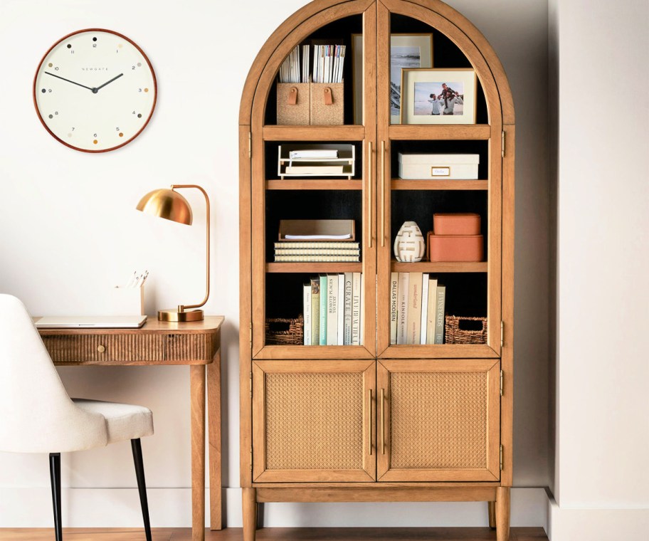 arched cabinet full of books and decor