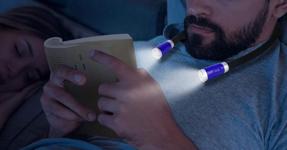 man in bed reading while wearing a neck light