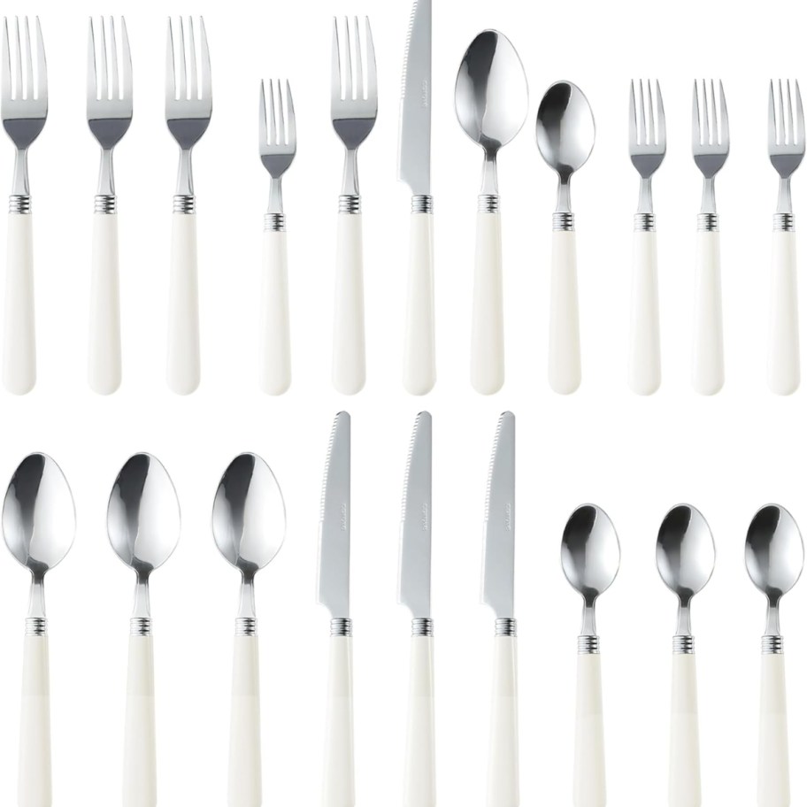 a set of silver flatware with cream handles
