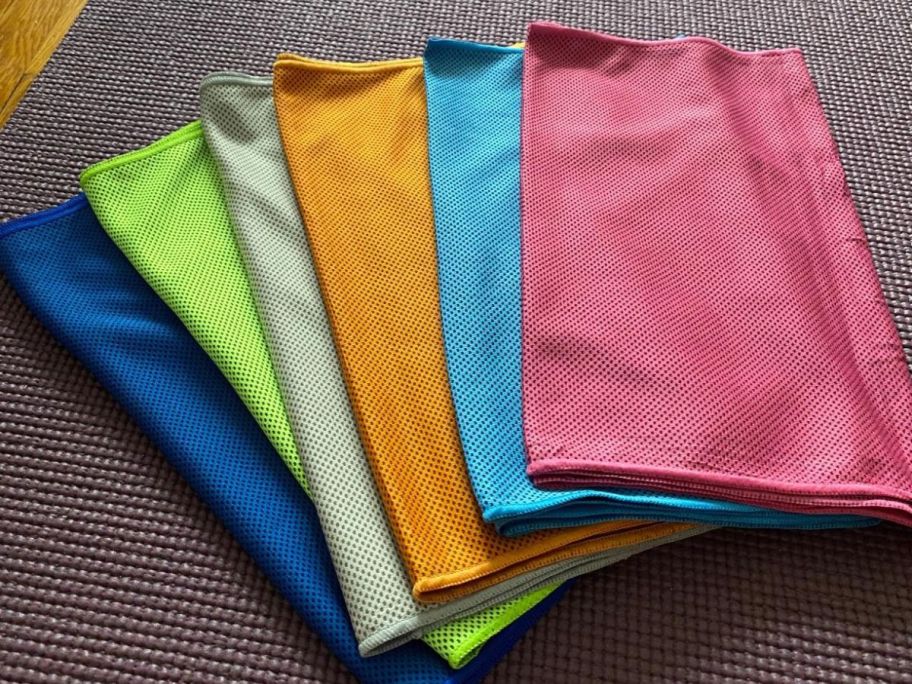 a blue, green, light green, orange, light blue, and a pink cooling towel laid out